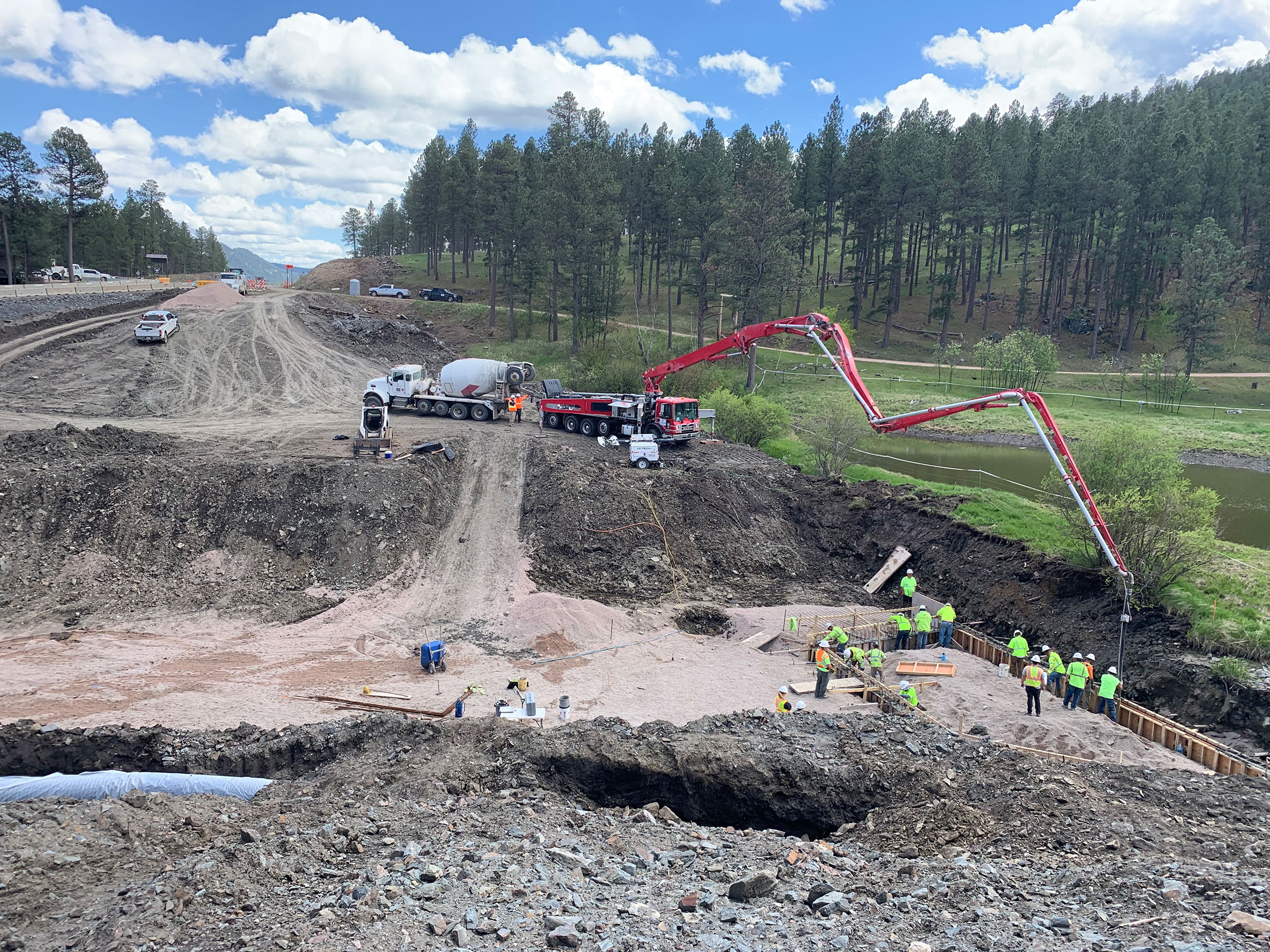 Construction workers working on pipe in ground.