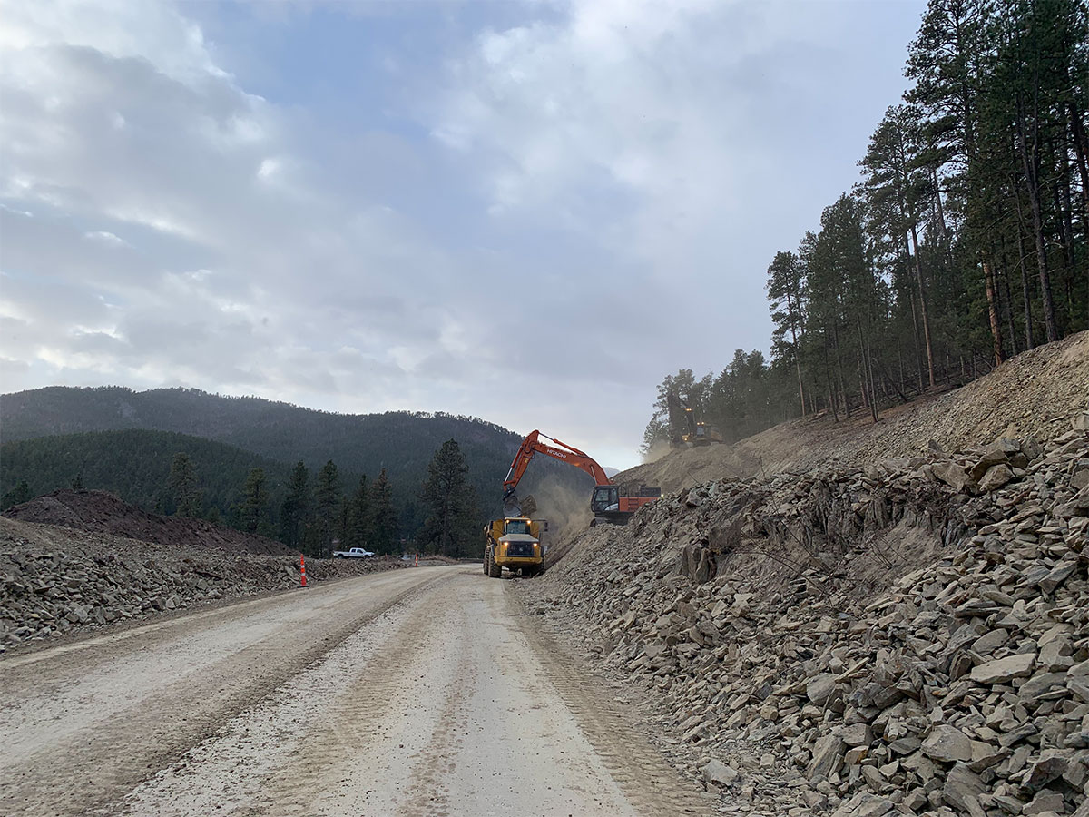 Machinery moving rocks into dump truck.